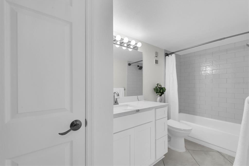 8 Glencoe Place, Unit 105 Dunedin, FL 34698 - Photo 16 of 44 a bathroom with a sink a toilet and shower