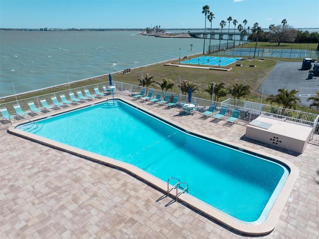 8 Glencoe Place, Unit 105 Dunedin, FL 34698 - Photo 26 of 44 a view of a tennis ground with a lake view