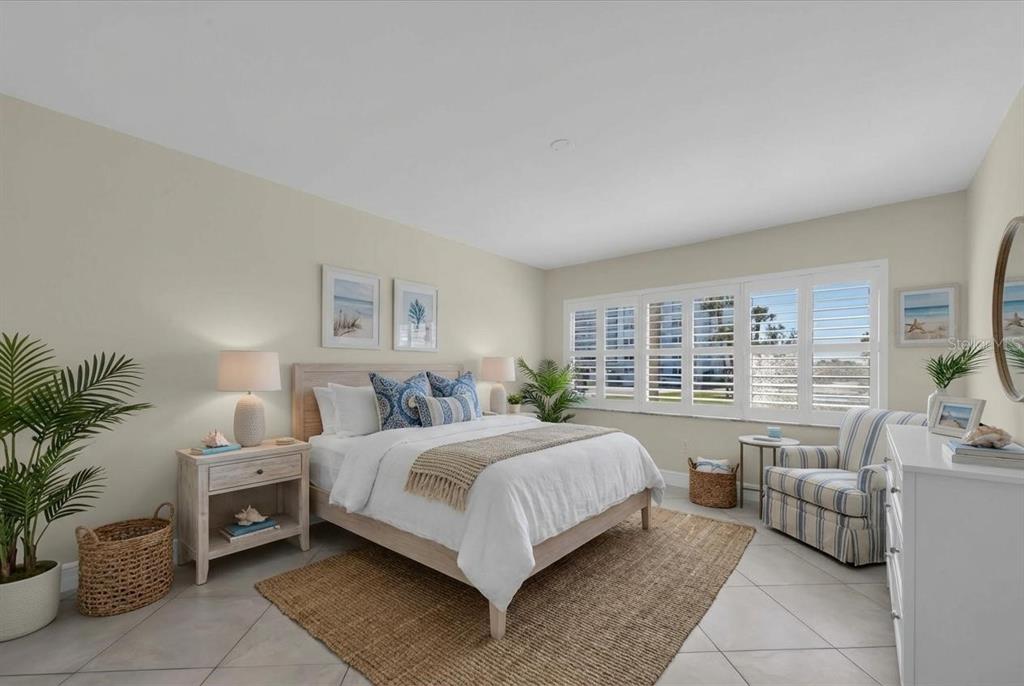 8 Glencoe Place, Unit 105 Dunedin, FL 34698 - Photo 5 of 44 a bedroom with a bed and a large window