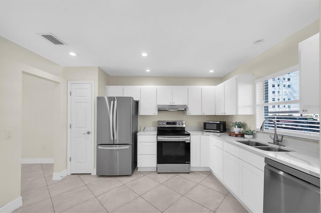 8 Glencoe Place, Unit 105 Dunedin, FL 34698 - Photo 7 of 44 a kitchen with stainless steel appliances granite countertop a refrigerator sink and stove