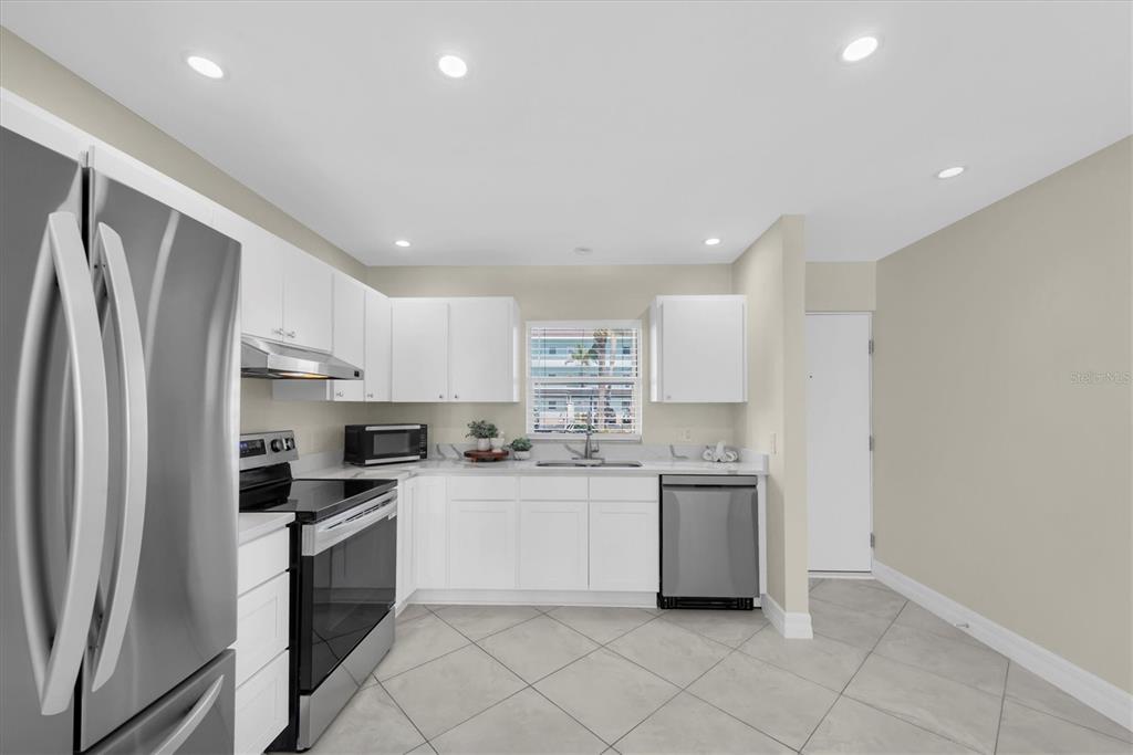 8 Glencoe Place, Unit 105 Dunedin, FL 34698 - Photo 9 of 44 a kitchen with a sink stainless steel appliances and cabinets