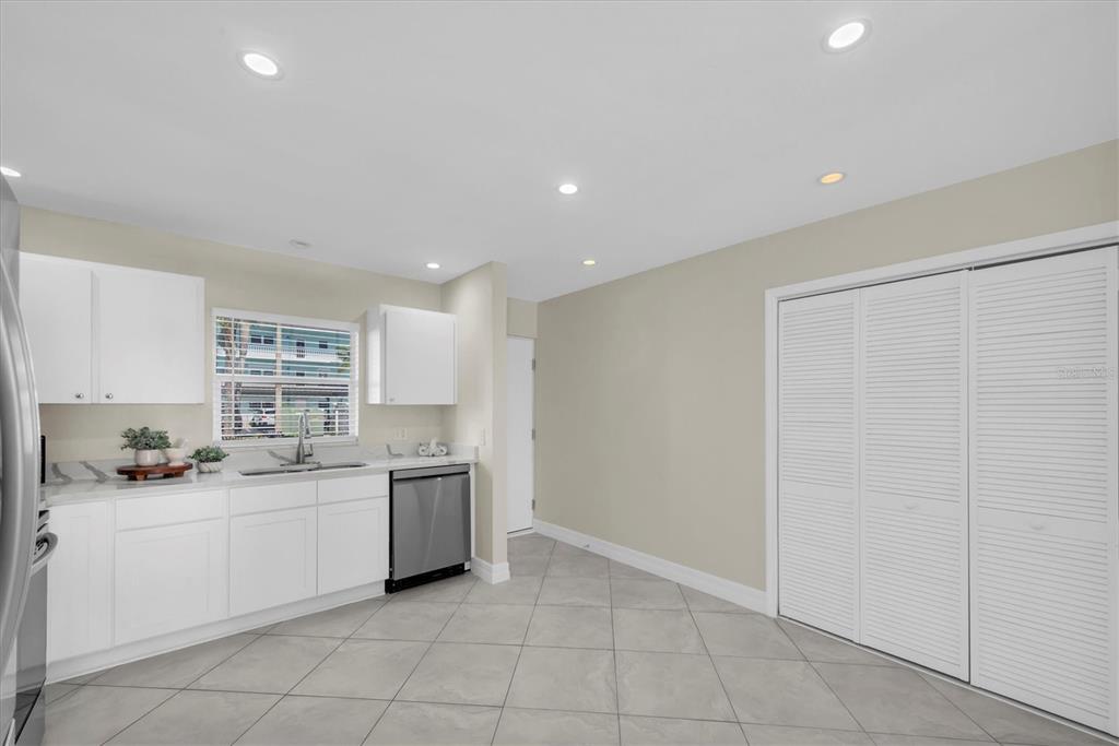 8 Glencoe Place, Unit 105 Dunedin, FL 34698 - Photo 10 of 44 a kitchen with a sink window and cabinets