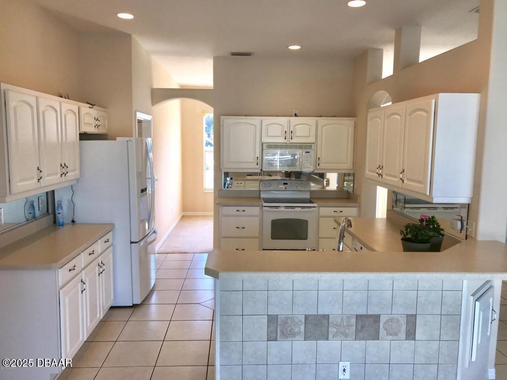 90 Buschman Drive Ponce Inlet, FL 32127 - Photo 4 of 37 a kitchen with stainless steel appliances granite countertop a stove a sink and a refrigerator