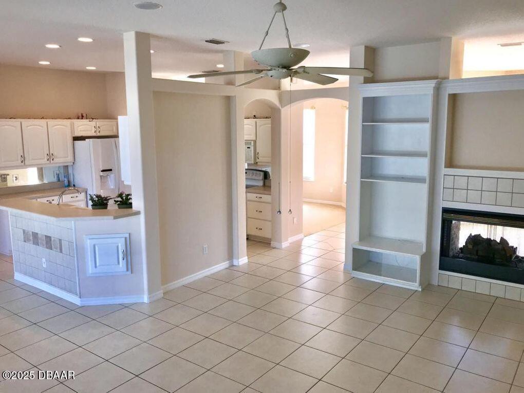 90 Buschman Drive Ponce Inlet, FL 32127 - Photo 6 of 37 a room with kitchen island granite countertop a refrigerator and a stove top oven