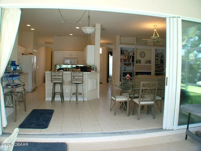 a kitchen with a dining table chairs and white appliances