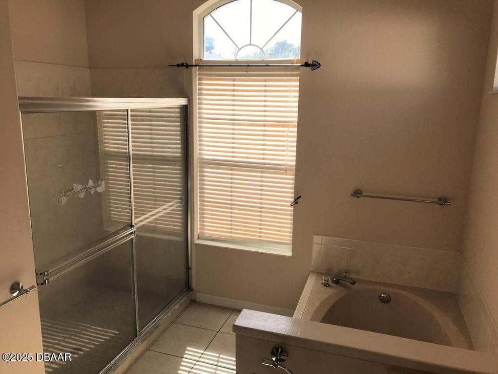 90 Buschman Drive Ponce Inlet, FL 32127 - Photo 10 of 37 a bathroom with a bathtub and a window