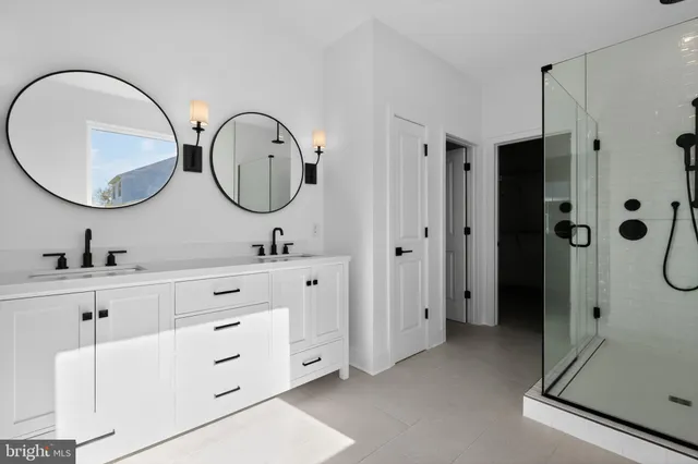 a bathroom with a double vanity sink mirror and shower