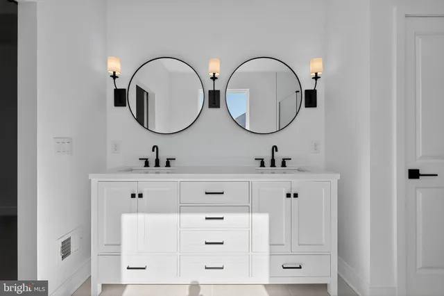a bathroom with double vanity sink and a mirror