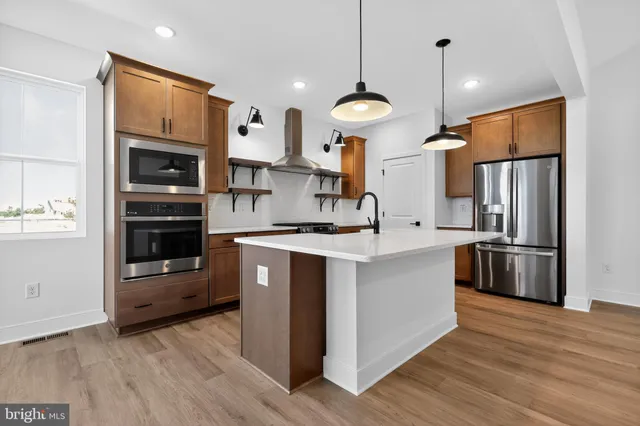 a kitchen with stainless steel appliances a refrigerator and a stove top oven