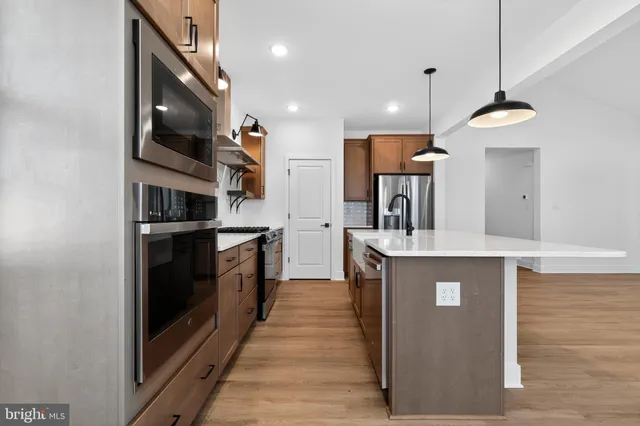 a kitchen with stainless steel appliances granite countertop a stove a sink and a refrigerator