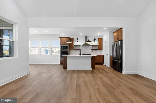 a large kitchen with a wooden floor and stainless steel appliances