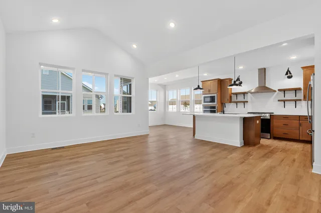 a large kitchen with stainless steel appliances granite countertop a large counter top and a wooden floors