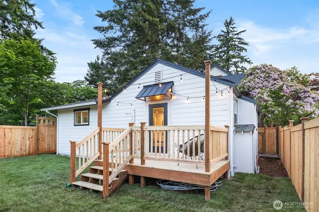 a view of a wooden deck with a small yard and a large tree