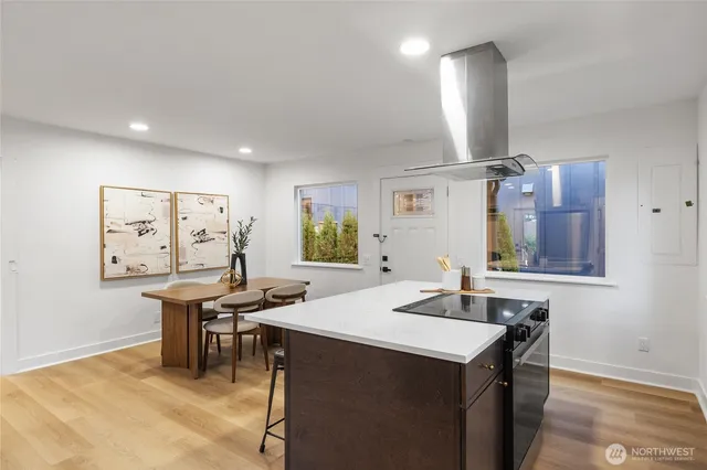 a kitchen with a table chairs and wooden floor