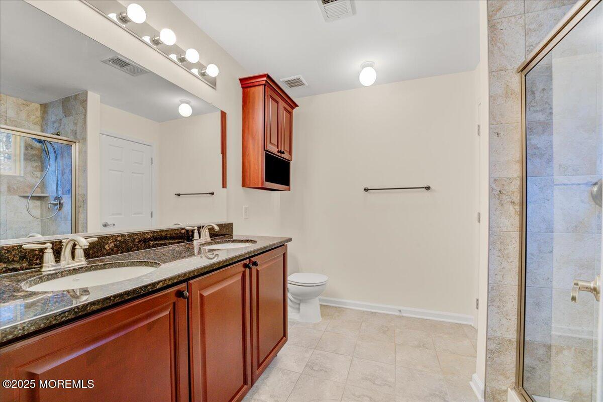 28 Santa Rosa Lane Tinton Falls, NJ 07753 - Photo 22 of 26 a bathroom with a granite countertop sink a toilet and mirror