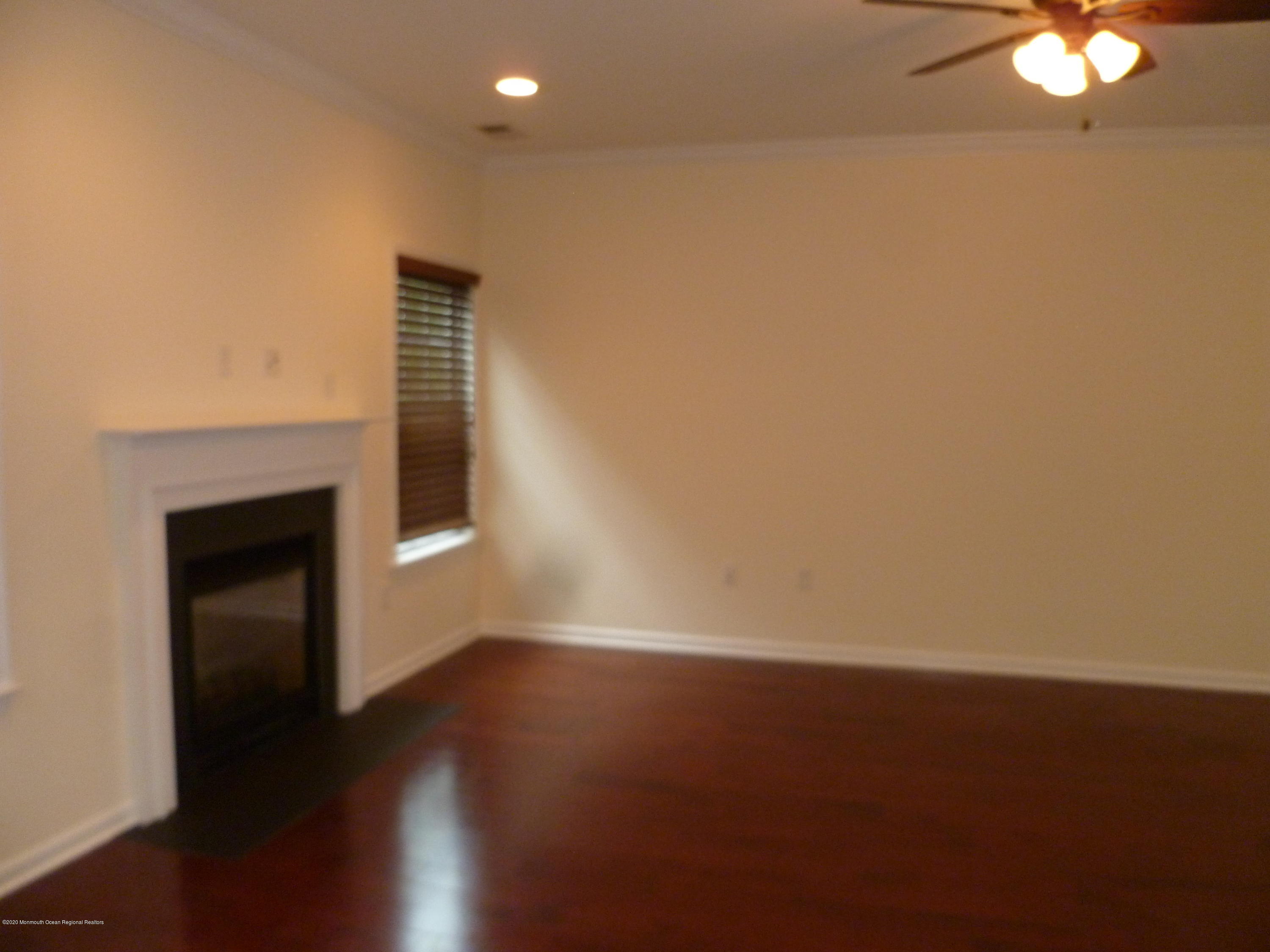 28 Santa Rosa Lane Tinton Falls, NJ 07753 - Photo 6 of 12 a view of an empty room with wooden floor and a fireplace