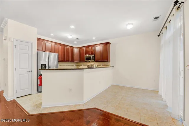 a kitchen with stainless steel appliances granite countertop a refrigerator sink and white cabinets