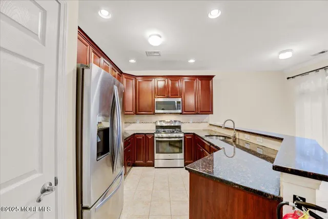 a kitchen with stainless steel appliances granite countertop sink refrigerator and microwave