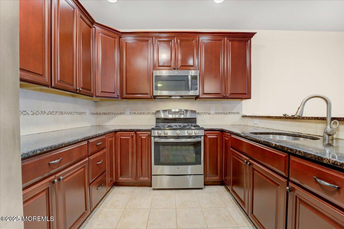 28 Santa Rosa Lane Tinton Falls, NJ 07753 - Photo 9 of 26 a kitchen with granite countertop a stove sink and cabinets