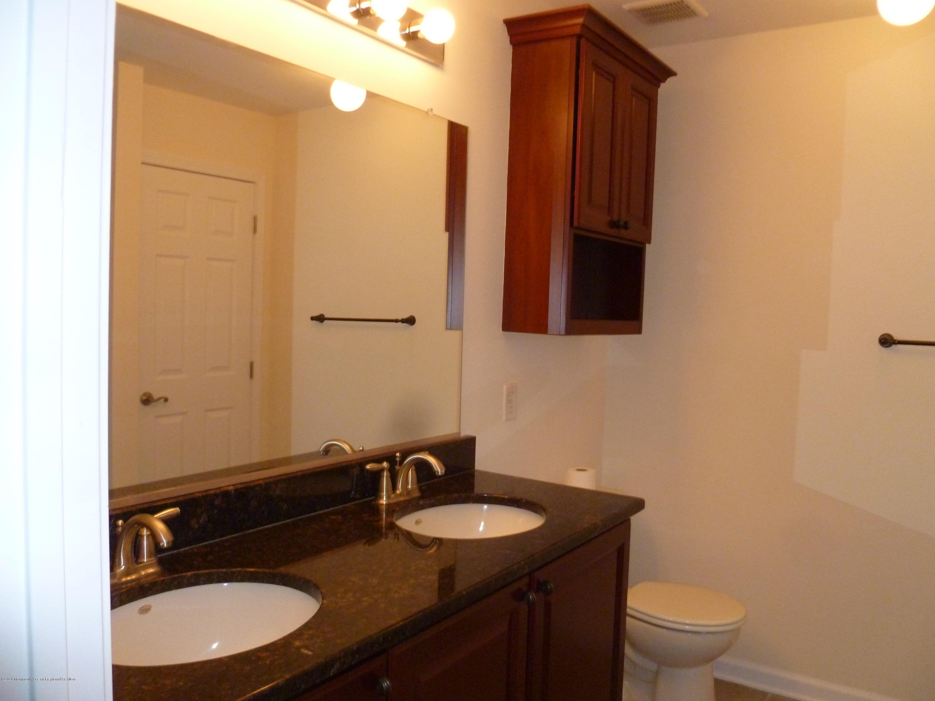 28 Santa Rosa Lane Tinton Falls, NJ 07753 - Photo 10 of 12 a bathroom with a granite countertop sink toilet and mirror