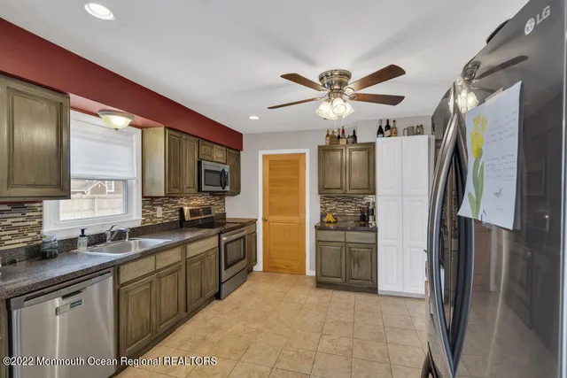 a large kitchen with a large counter top appliances and refrigerator