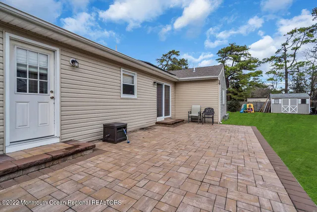 a view of a backyard with plants and brick wall
