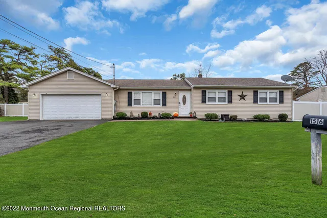 a front view of a house with a garden and trees