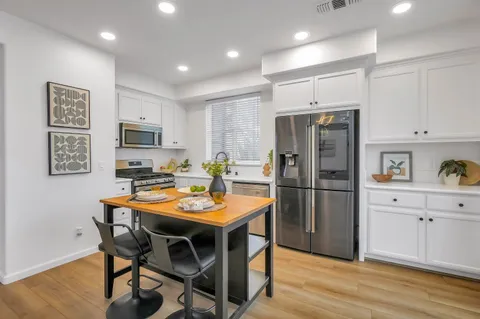 a kitchen with kitchen island a refrigerator stove microwave and cabinets