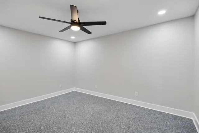 an empty room with closet and a ceiling fan
