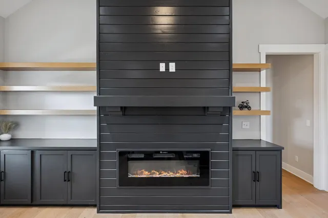 a kitchen with stainless steel appliances kitchen island granite countertop a refrigerator a stove a sink a dining table and chairs with wooden floor