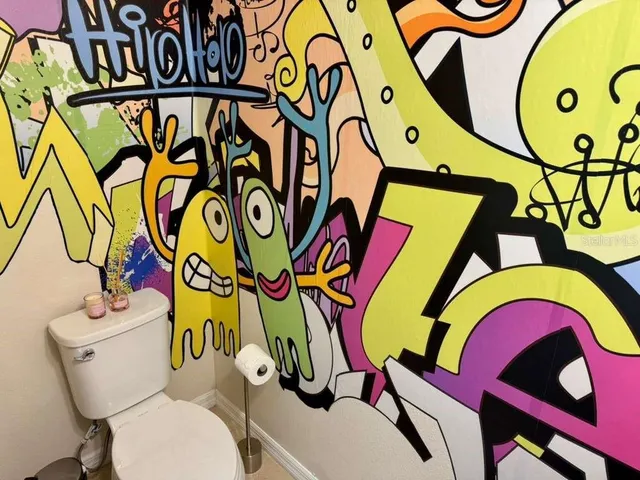 a bathroom with a painting on the wall and a window