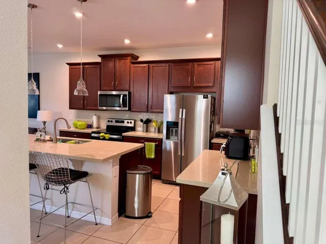 a kitchen with stainless steel appliances a refrigerator and a stove top oven