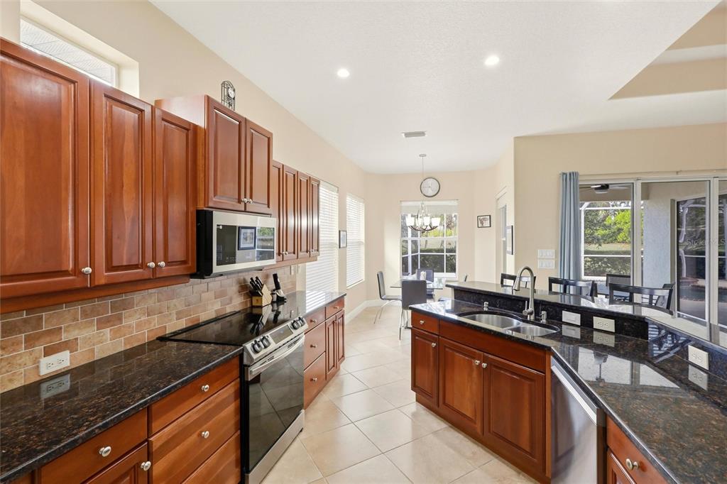 508 Fallbrook Drive Venice, FL 34292 - Photo 5 of 20 a large kitchen with granite countertop a sink and a stove top oven