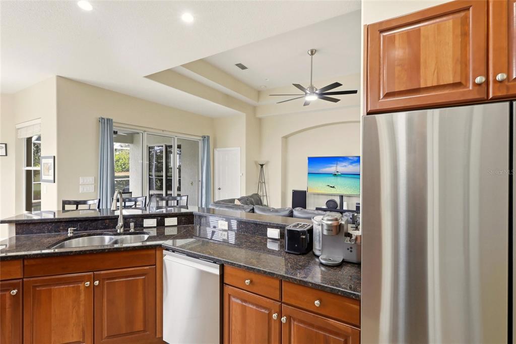 508 Fallbrook Drive Venice, FL 34292 - Photo 6 of 20 a kitchen with stainless steel appliances granite countertop a sink a stove and a refrigerator with wooden floor