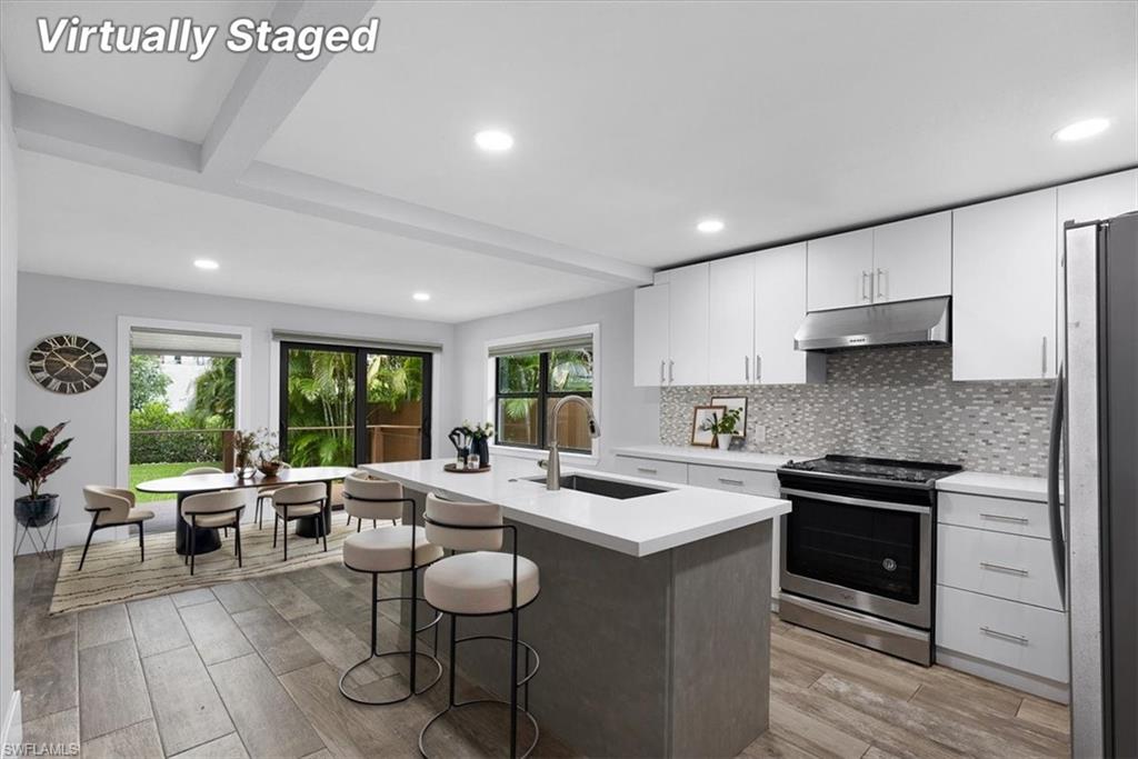 3240 Collee Court Naples, FL 34112 - Photo 14 of 42 a kitchen with a stove a sink and a refrigerator
