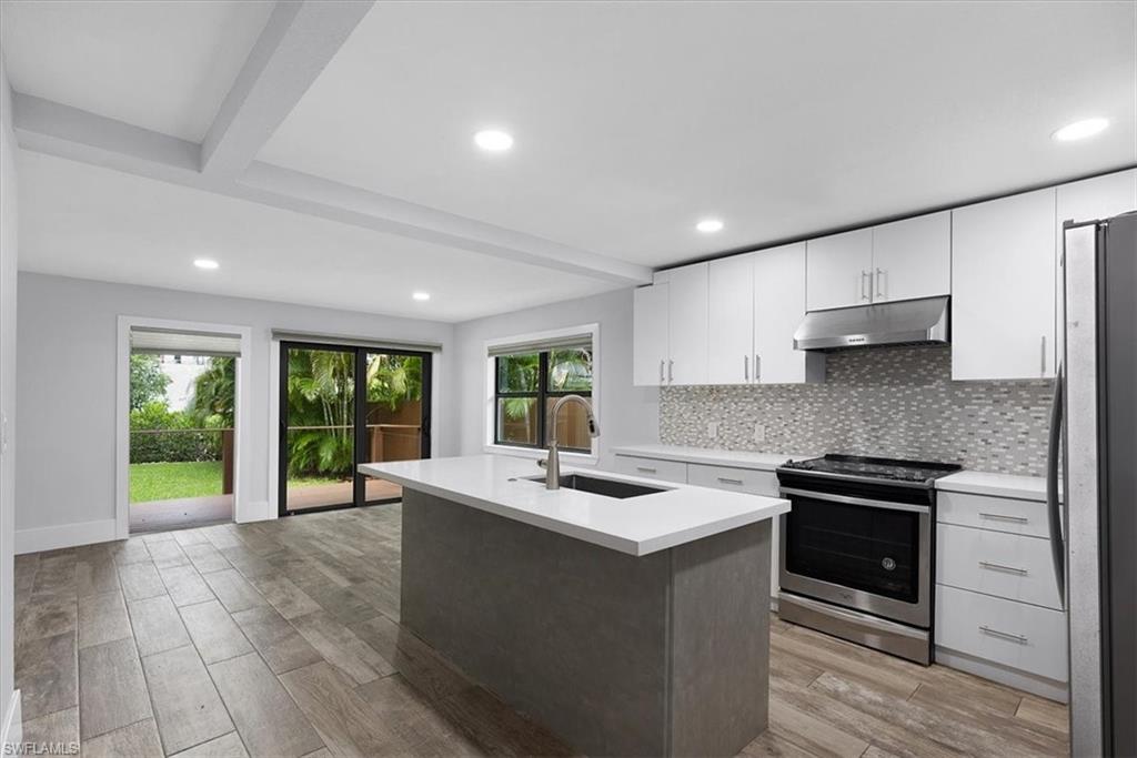 3240 Collee Court Naples, FL 34112 - Photo 15 of 42 a kitchen with a sink stove and cabinets