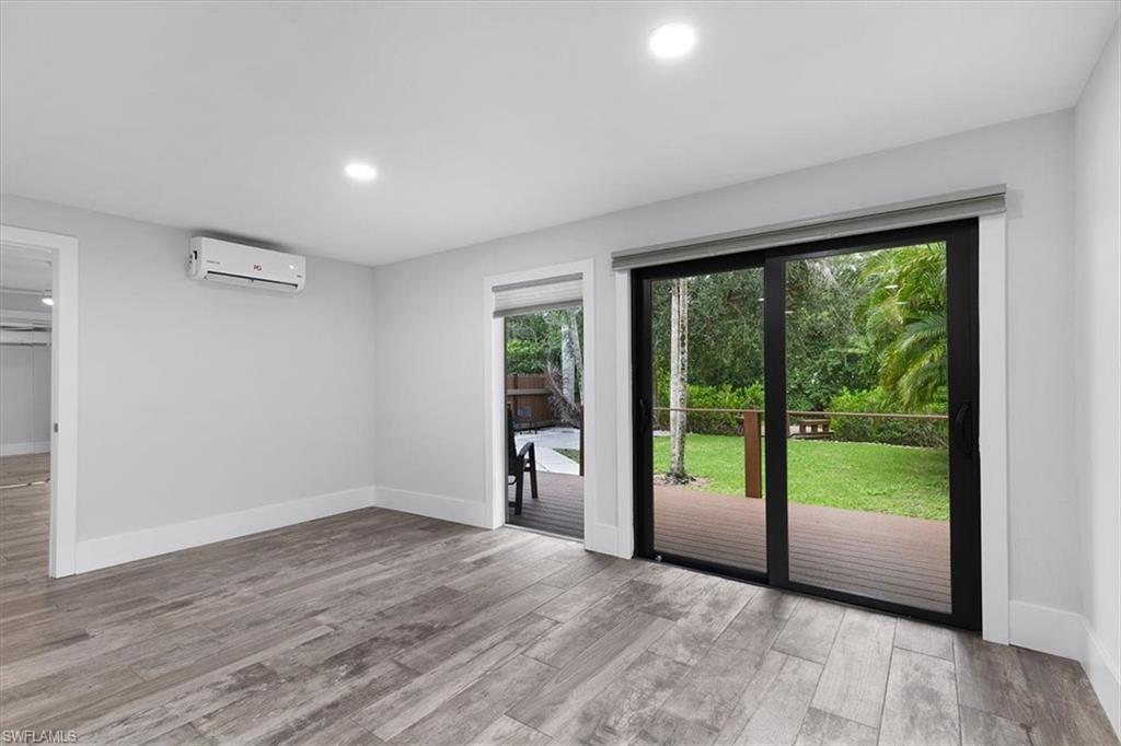 3240 Collee Court Naples, FL 34112 - Photo 18 of 42 a view of an empty room with wooden floor and a window