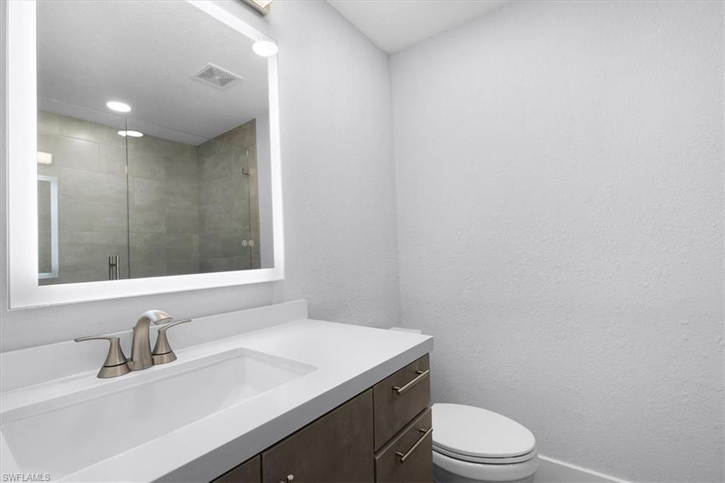 3240 Collee Court Naples, FL 34112 - Photo 23 of 42 a bathroom with a sink a toilet and mirror