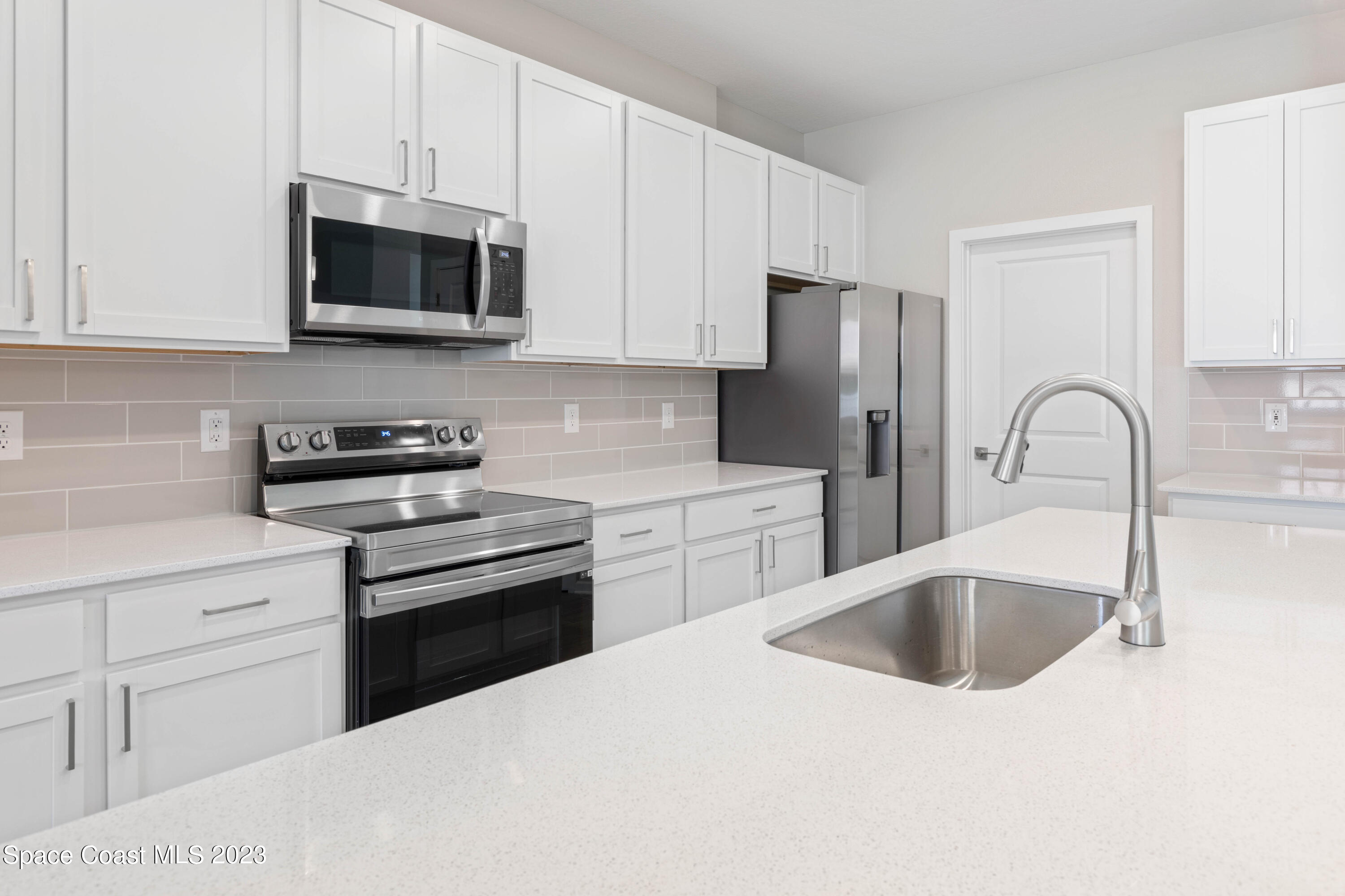 407 Hallcrest Street Palm Bay, FL 32908 - Photo 9 of 25 a kitchen with stainless steel appliances granite countertop a sink a stove a microwave and refrigerator