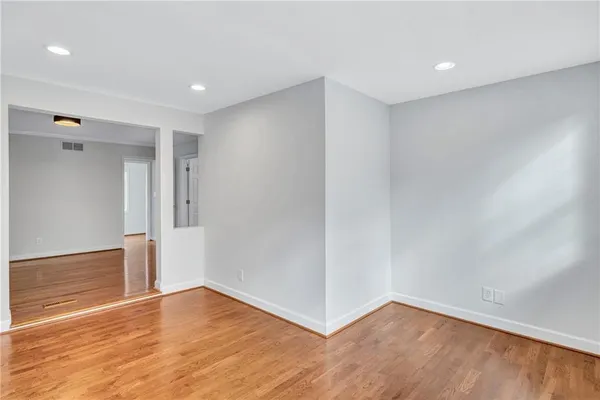 a view of an empty room with wooden floor