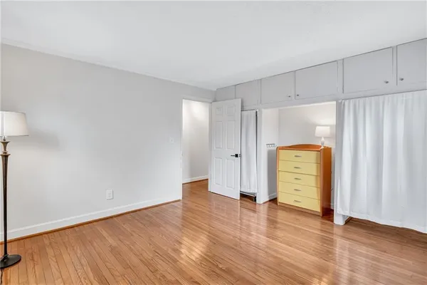 a view of empty room with wooden floor and cabinet