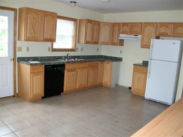 146 Brookside Road Orange, MA 01364 - Photo 3 of 9 a kitchen with granite countertop a refrigerator a sink a stove a microwave a counter and cabinets