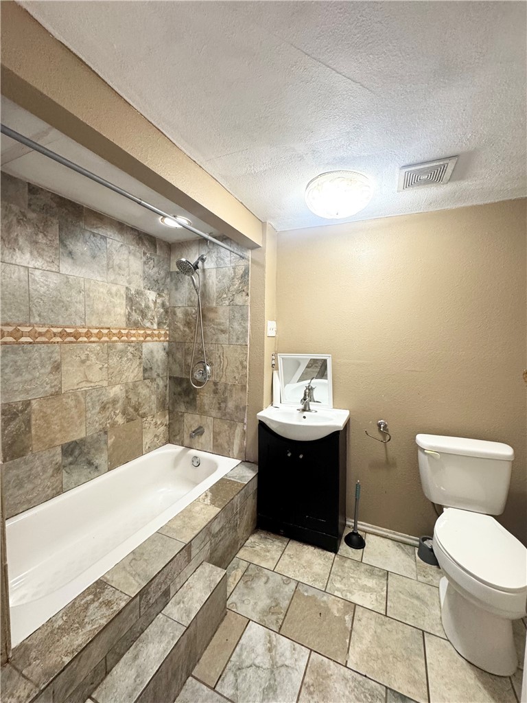 403 Staples Street Alice, TX 78332 - Photo 12 of 15 a bathroom with a sink a toilet and bathtub