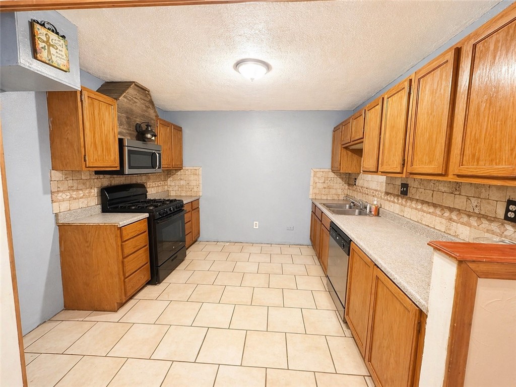 403 Staples Street Alice, TX 78332 - Photo 4 of 15 a kitchen with stainless steel appliances a sink stove and cabinets