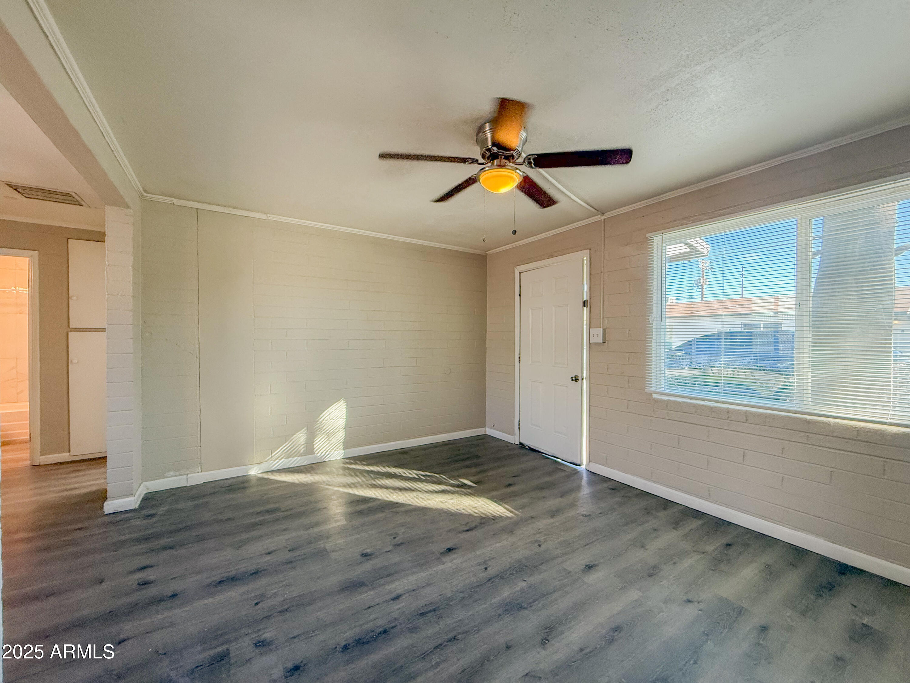2 East Navajo Road, Unit E Tucson, AZ 85705 - Photo 9 of 15 a view of an empty room with window and wooden floor