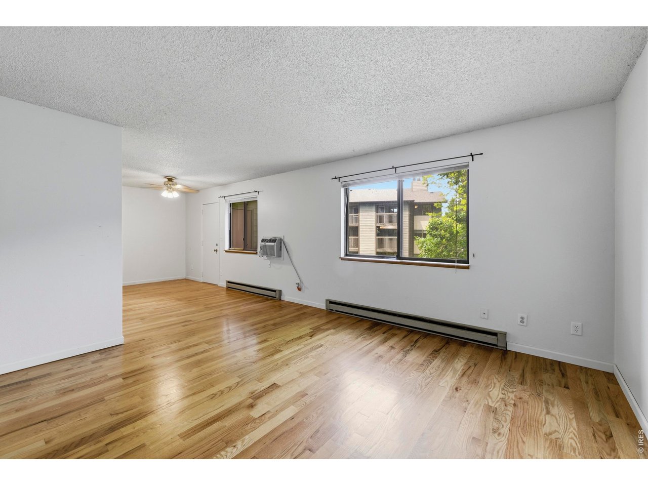 925 Columbia Road, Unit 824 Fort Collins, CO 80525 - Photo 7 of 36 an empty room with wooden floor and windows