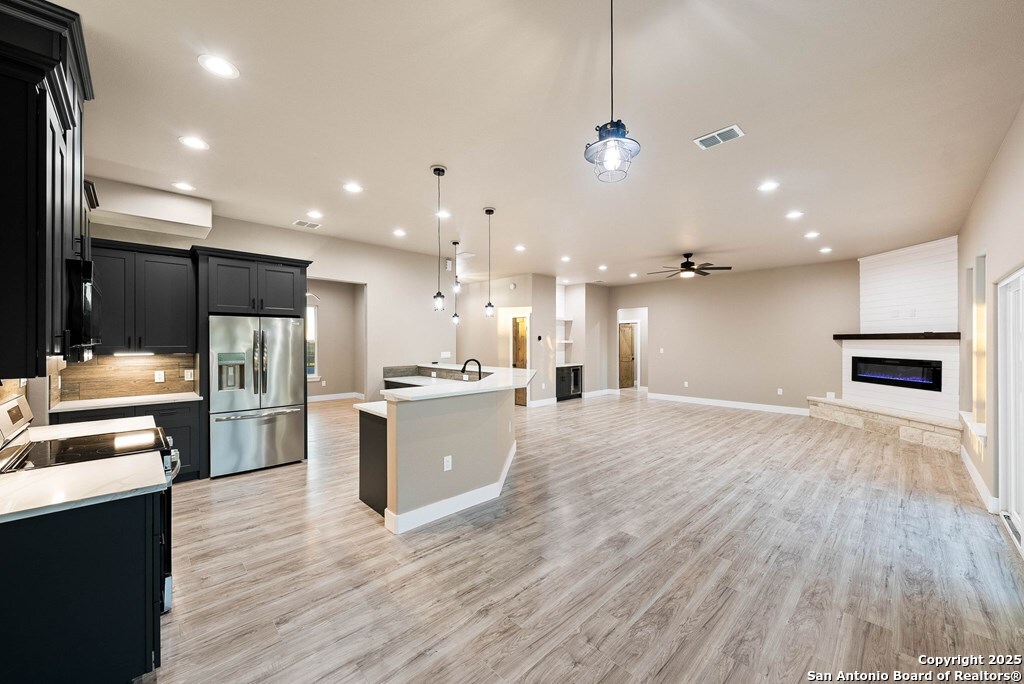 502 Sumack Kerrville, TX 78028 - Photo 13 of 58 a large kitchen with kitchen island a large counter top stainless steel appliances and cabinets
