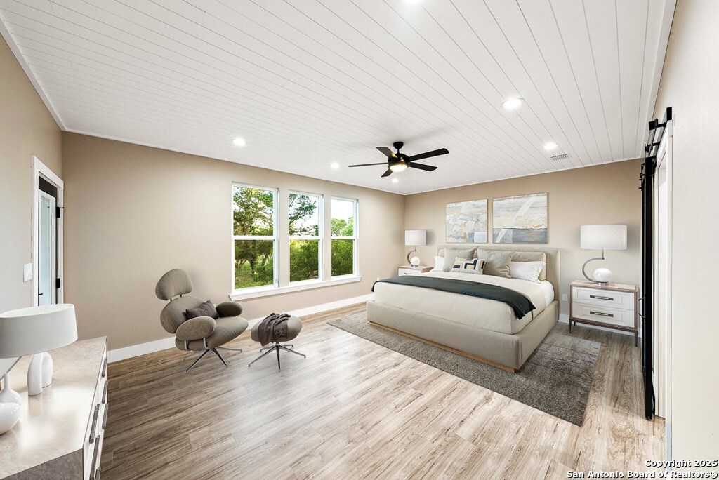 502 Sumack Kerrville, TX 78028 - Photo 15 of 58 a bedroom with a bed and wooden floor