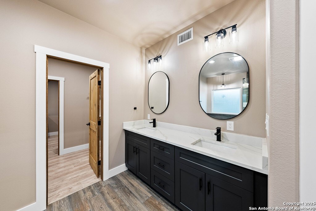 502 Sumack Kerrville, TX 78028 - Photo 18 of 58 a en suite bathroom with a double vanity sink and a mirror