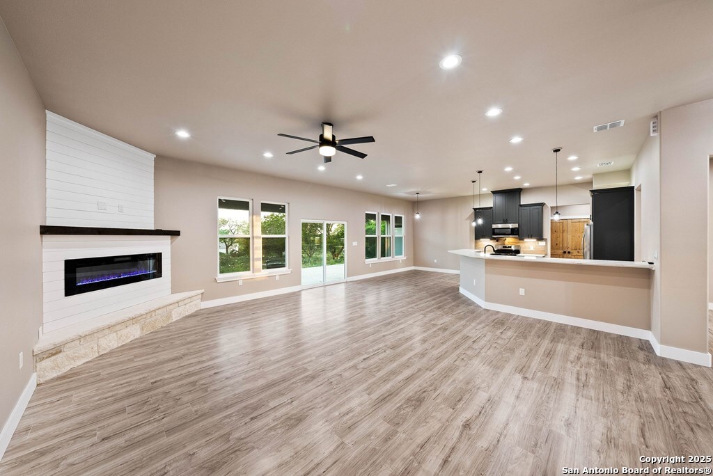 502 Sumack Kerrville, TX 78028 - Photo 2 of 58 a view of an empty room with wooden floor and a kitchen